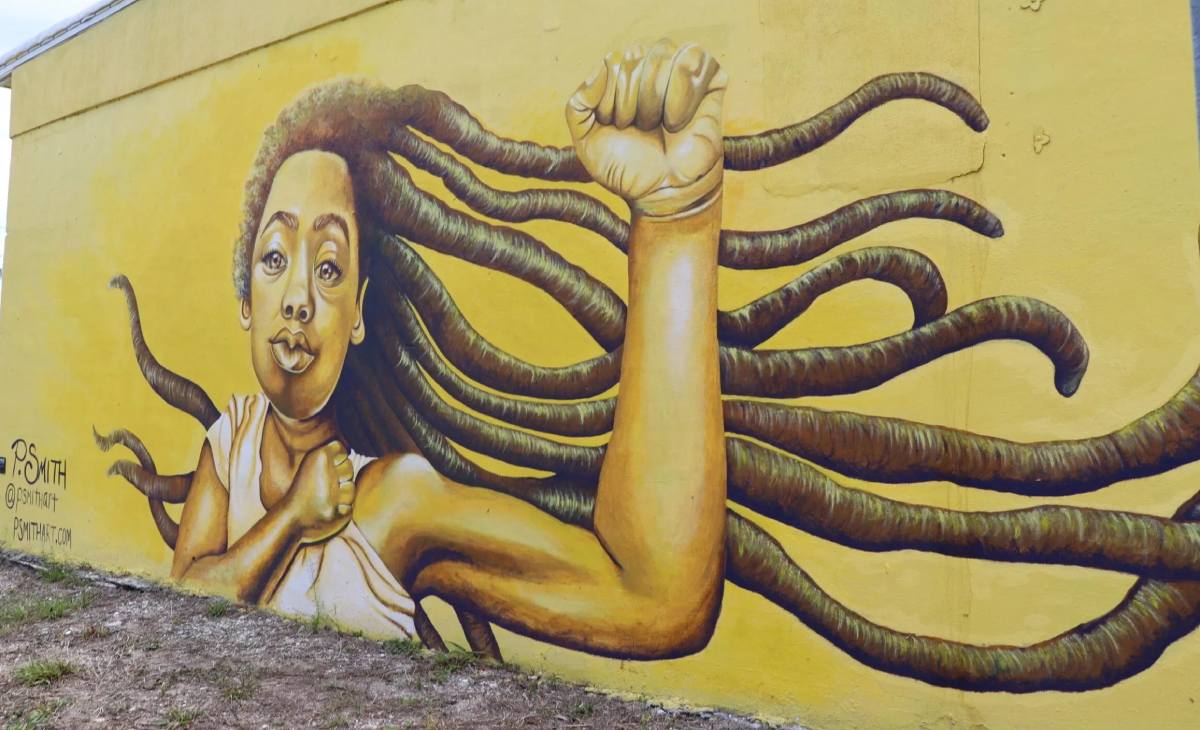 A mural of a woman with dreadlocks on her head.