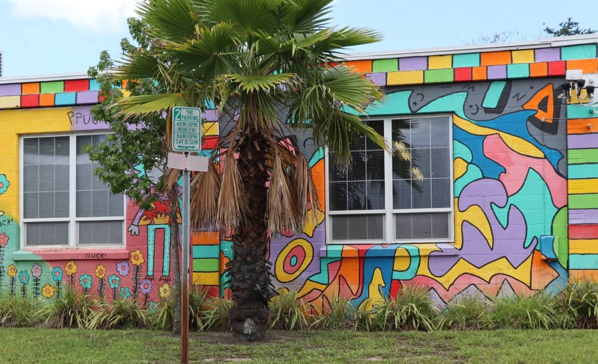 A colorful building with a palm tree in front of it.