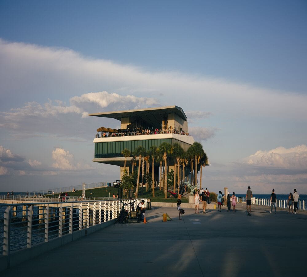 A pier with people sitting on it and trees in the background.